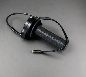 Surron throttle for e-bikes, black twist throttle with textured rubber grip, cable and connector, top view on gray