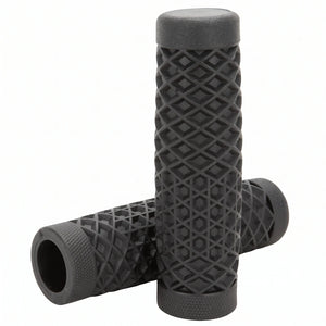 Surron grips in black waffle pattern, one grip standing on the other to show the open bore and knurled ends