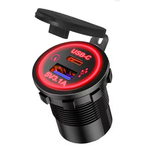 Surron USB charger, 1 USB-C and 1 USB-A port with red LED ring and flip-up rubber cap, on a white background