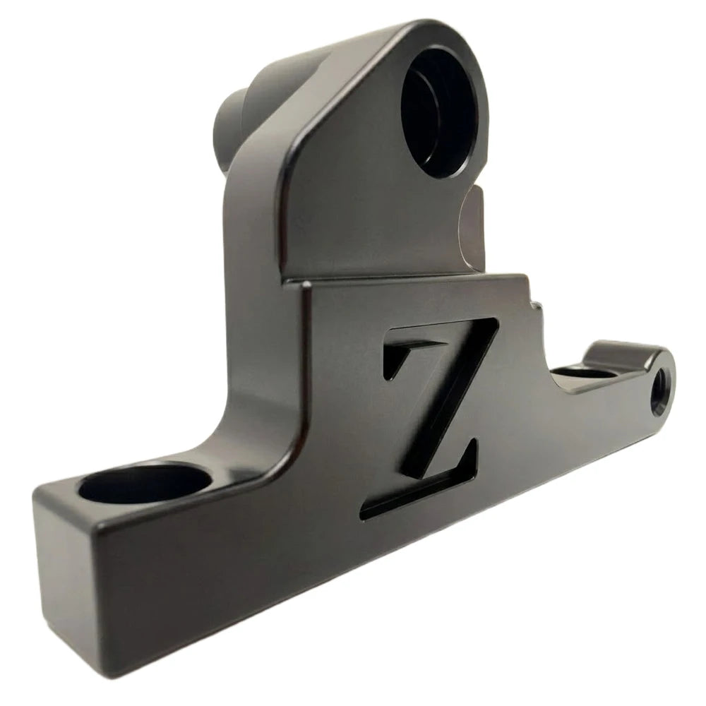Surron moto front brake caliper mounting bracket, CNC-machined gunmetal anodized finish, cut-out FactoryZ Z logo, close-up angle