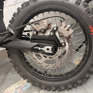 Surron Ultra Bee big brake kit installed on the rear wheel, two Nibbi calipers on a black bracket, 270mm wave rotor