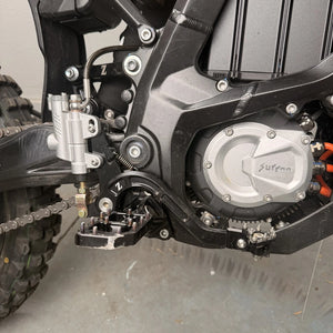 Surron Ultra Bee foot brake installed on the bike, silver HSK master cylinder, braided line, black lever and peg