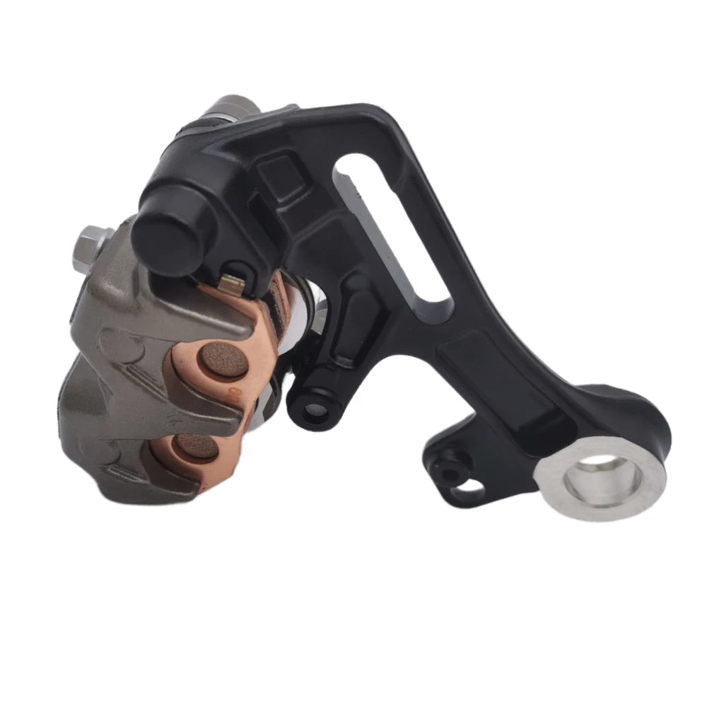 Surron Ultra Bee OEM rear brake caliper, underside angle showing copper sintered pads, caliper assembly, and black caliper bracket