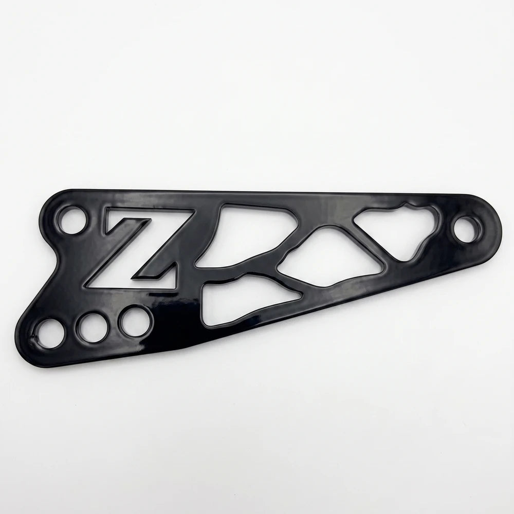 Talaria X3 shift lock bracket, black anodized billet aluminum with Z logo and skeletonized web cutouts, mounting holes