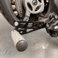 Talaria XXX shift lock kit installed, black CNC FactoryZ Z-cutout bracket with blue anodized bolts near belt-drive sprocket, close-up